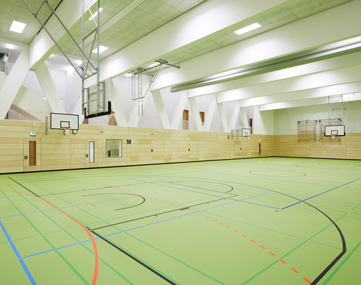 Neubau Sporthalle der Grundschule Rebstock: Innenperspektive, bunte Markierung auf dem grünen Boden der Halle